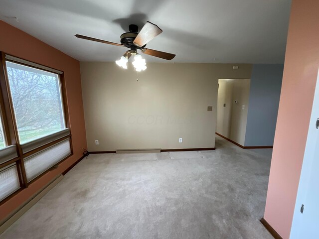 unfurnished room featuring light carpet, a baseboard radiator, and ceiling fan