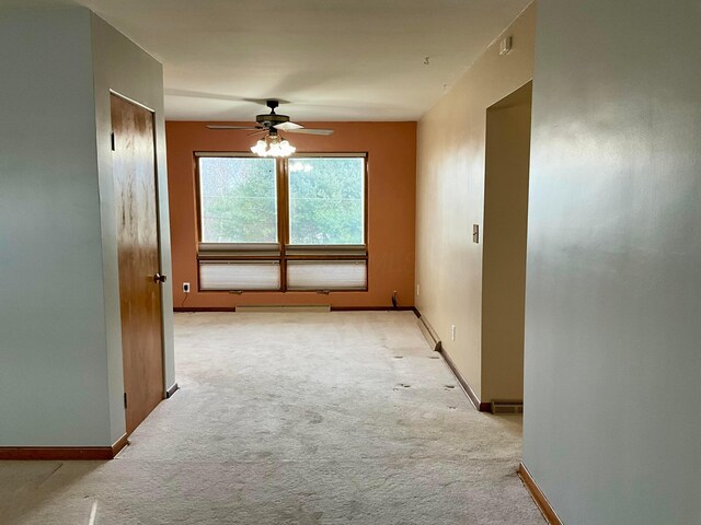 empty room with ceiling fan and light colored carpet