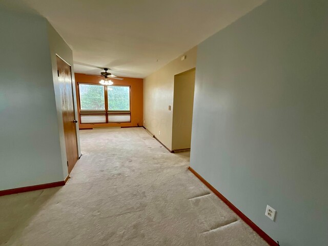 hallway featuring light colored carpet