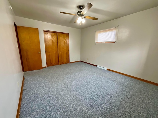 unfurnished bedroom with carpet, a closet, ceiling fan, and a baseboard heating unit