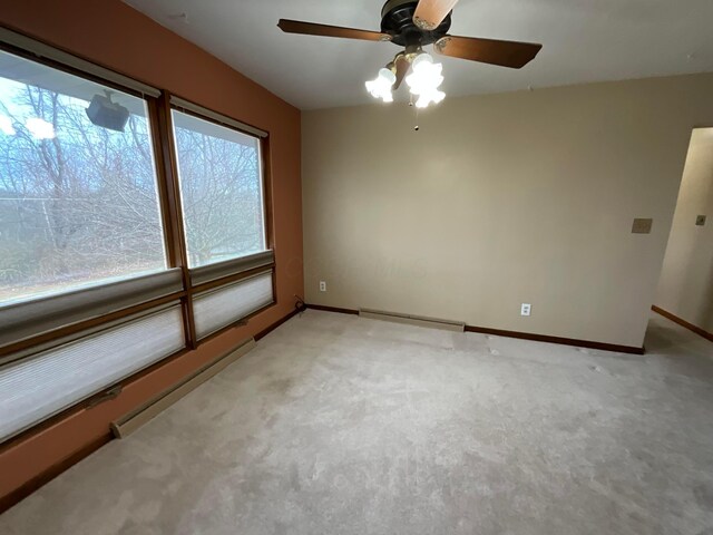 carpeted spare room featuring ceiling fan and a baseboard heating unit