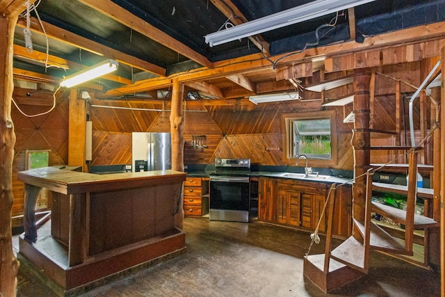 kitchen featuring sink, stainless steel appliances, and wooden walls