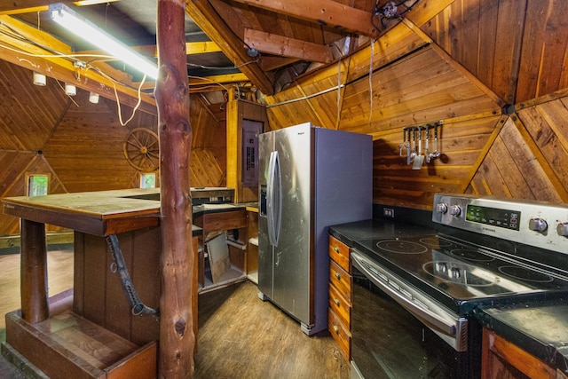 kitchen with wood walls, wood-type flooring, stainless steel appliances, and vaulted ceiling