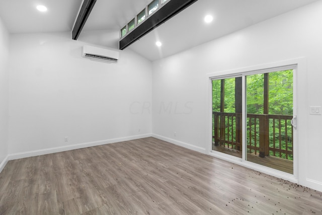 unfurnished room with lofted ceiling with beams, an AC wall unit, and light hardwood / wood-style flooring