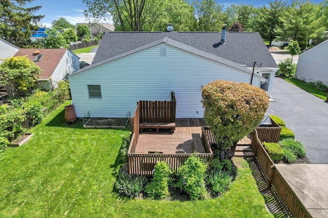 rear view of property featuring a lawn and a wooden deck