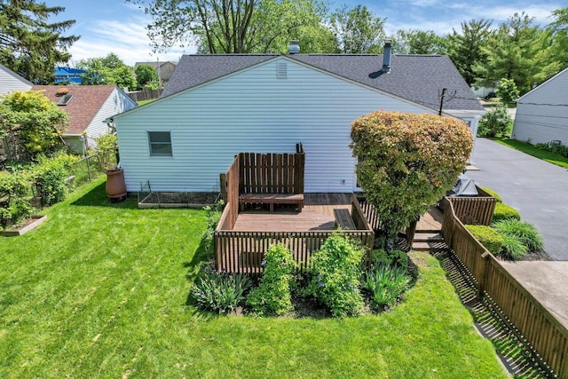 rear view of property featuring a lawn and a wooden deck