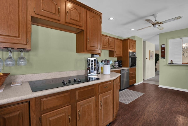 kitchen with dark wood-type flooring, black appliances, and ceiling fan with notable chandelier