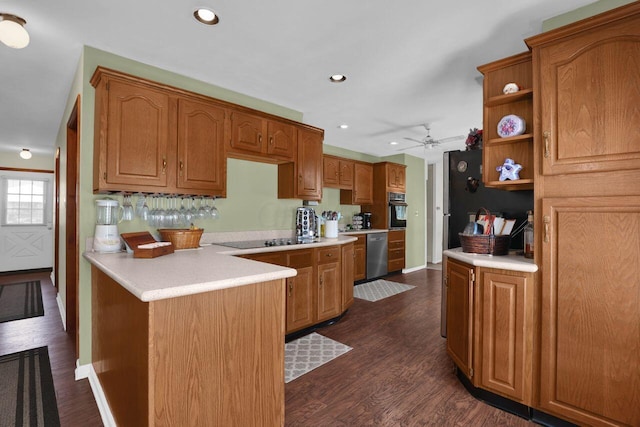 kitchen with kitchen peninsula, ceiling fan, dark wood-type flooring, and black appliances