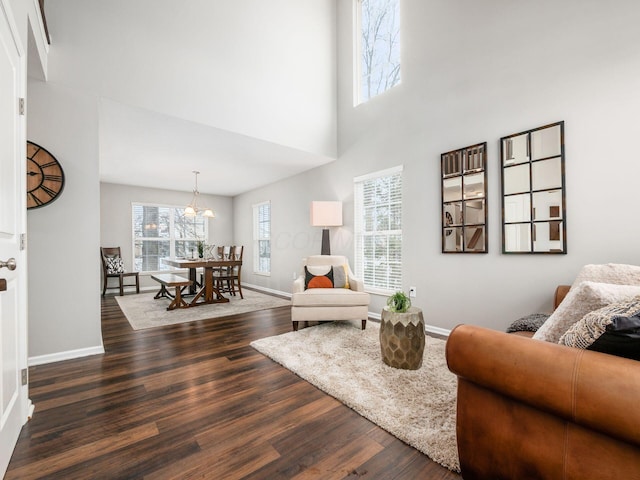 living room featuring a high ceiling, a healthy amount of sunlight, and dark hardwood / wood-style floors