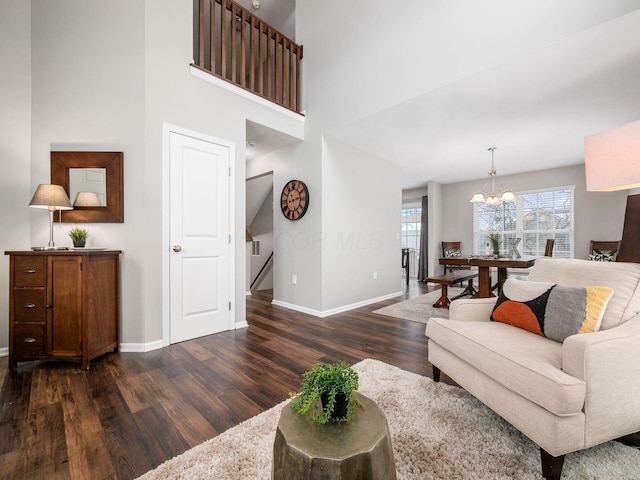 living room with dark wood-type flooring and a chandelier