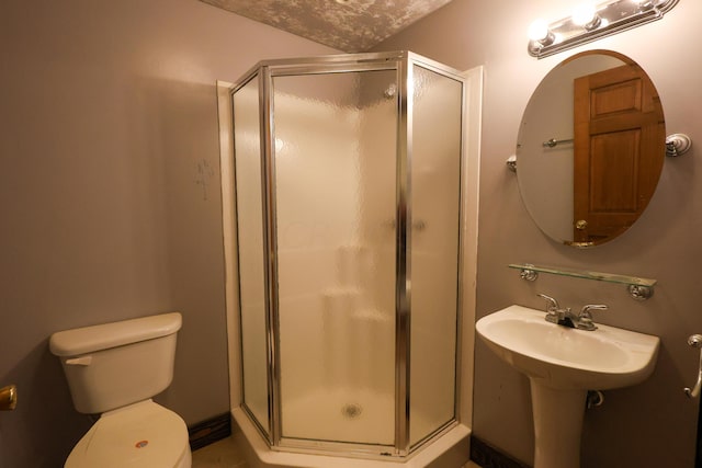 bathroom featuring toilet and a shower with shower door