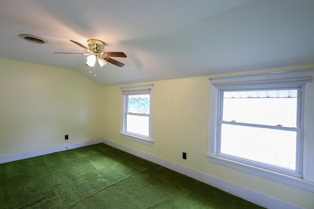 unfurnished room with carpet, vaulted ceiling, a wealth of natural light, and ceiling fan