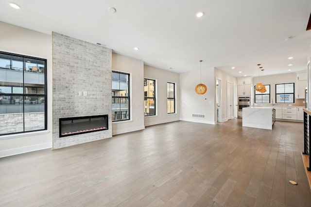 unfurnished living room with a large fireplace and hardwood / wood-style floors