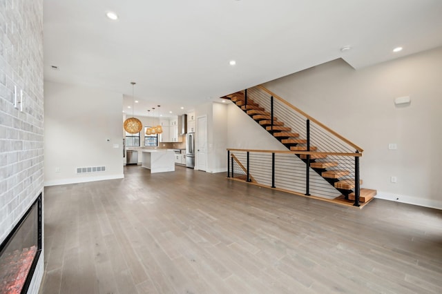 unfurnished living room with a large fireplace and wood-type flooring