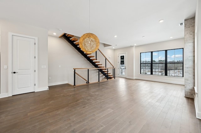 unfurnished living room featuring dark hardwood / wood-style floors and a chandelier