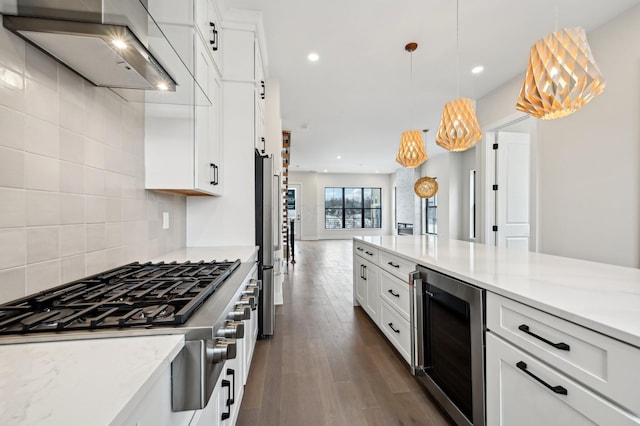 kitchen with wine cooler, tasteful backsplash, decorative light fixtures, cooktop, and wall chimney exhaust hood