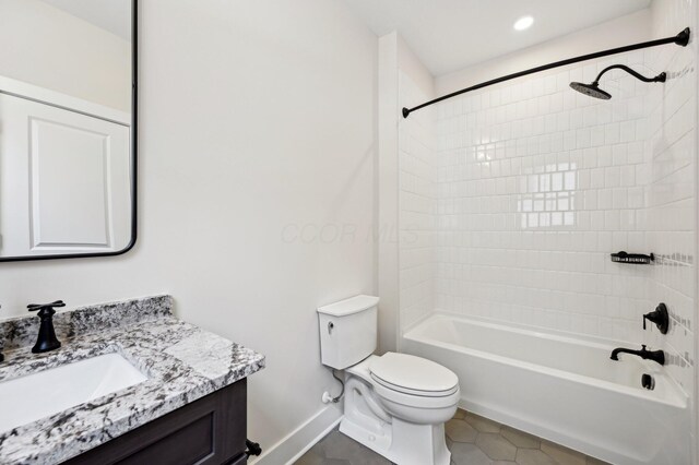 full bathroom featuring tiled shower / bath, vanity, toilet, and tile patterned flooring