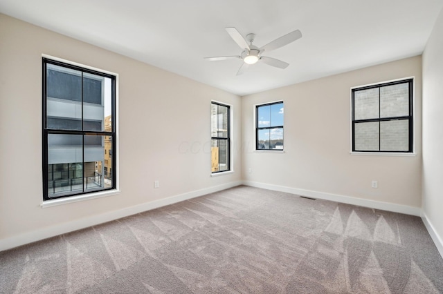 empty room with ceiling fan and carpet