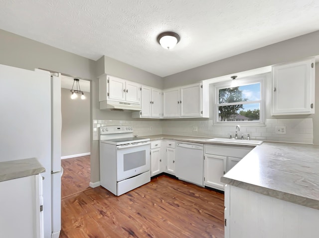 kitchen with white cabinets, white appliances, dark hardwood / wood-style floors, and backsplash