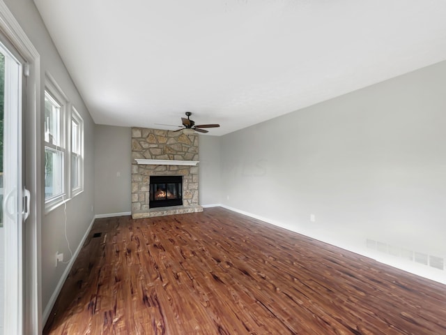 unfurnished living room with hardwood / wood-style flooring, ceiling fan, a fireplace, and vaulted ceiling