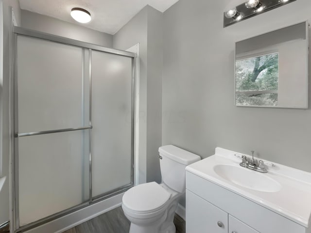 bathroom featuring walk in shower, hardwood / wood-style floors, a textured ceiling, toilet, and vanity