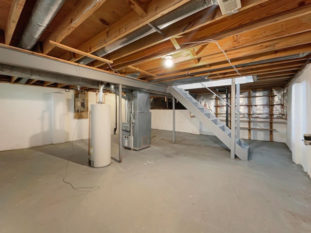 basement featuring heating unit, electric panel, and water heater