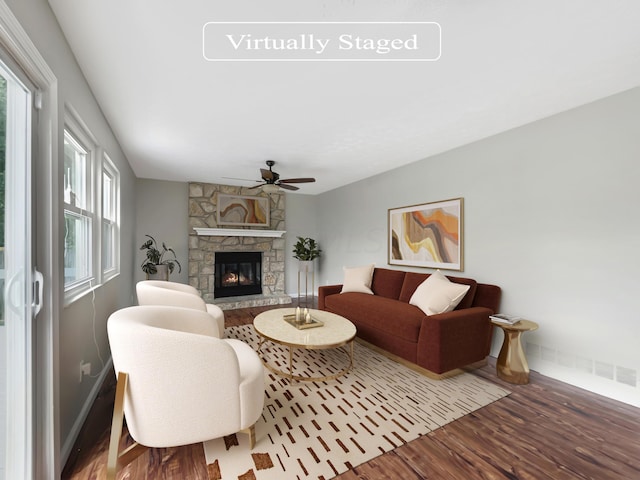 living room featuring a stone fireplace, ceiling fan, and hardwood / wood-style flooring