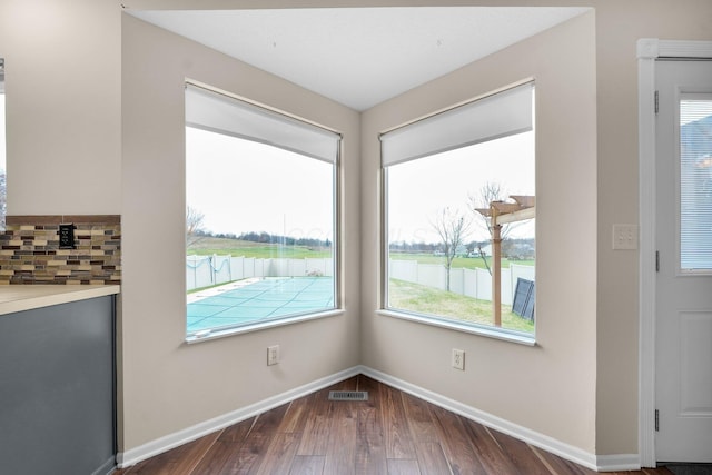 interior space featuring dark hardwood / wood-style flooring and a water view