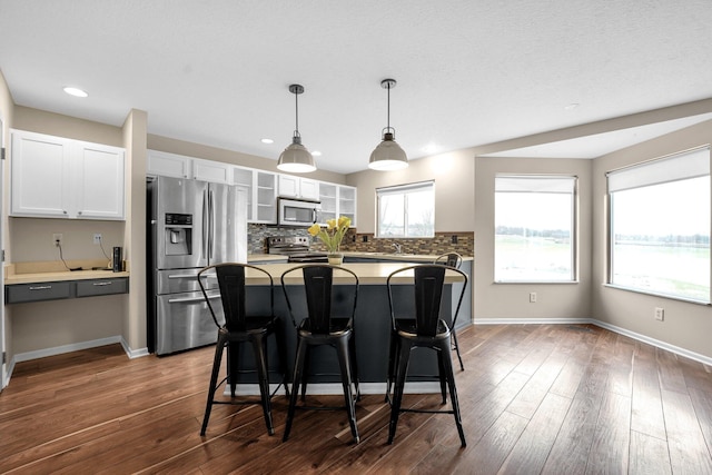 kitchen featuring plenty of natural light, a center island, white cabinetry, and appliances with stainless steel finishes