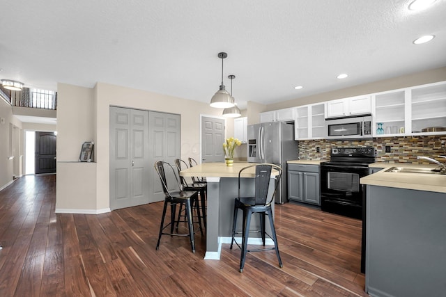 kitchen with stainless steel appliances, sink, pendant lighting, gray cabinets, and dark hardwood / wood-style floors