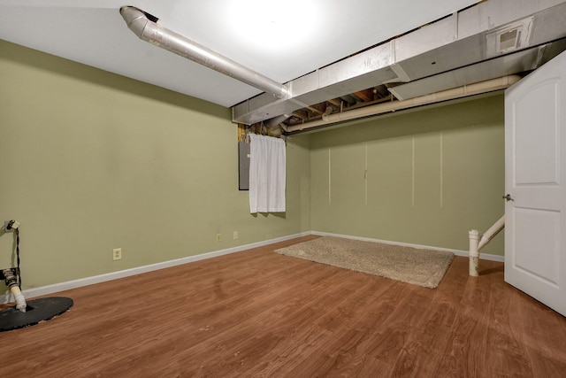 basement with electric panel and hardwood / wood-style floors