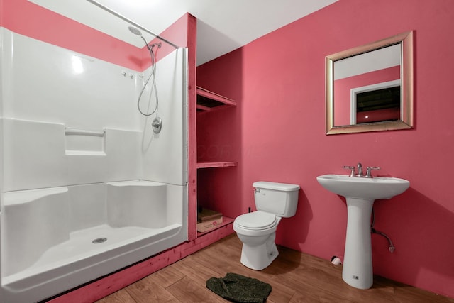 bathroom with hardwood / wood-style floors, sink, toilet, and walk in shower