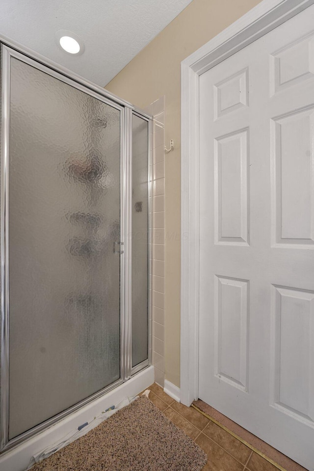 bathroom featuring tile patterned flooring and a shower with door