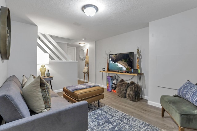 living room featuring wood-type flooring and a textured ceiling