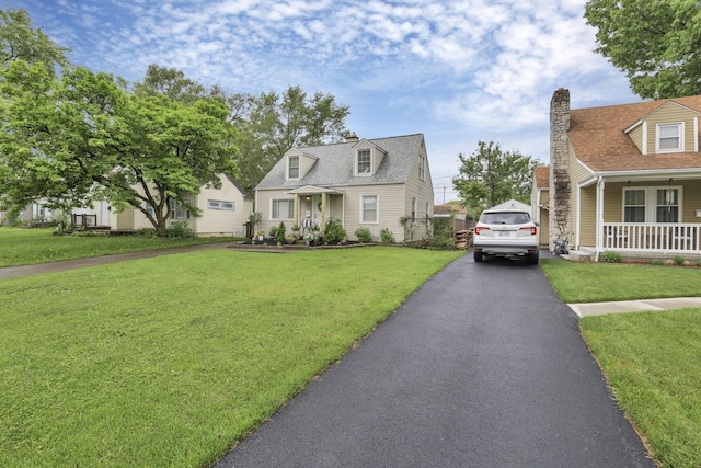 cape cod home featuring a porch and a front lawn