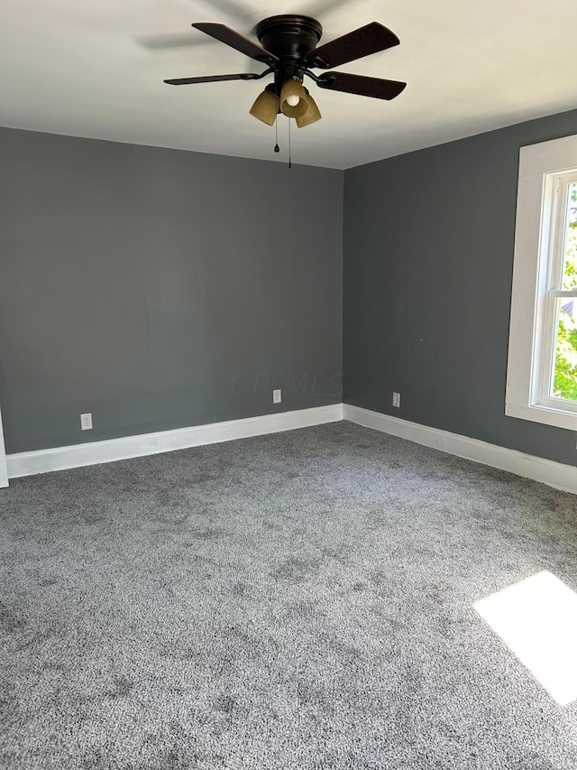 carpeted empty room featuring ceiling fan