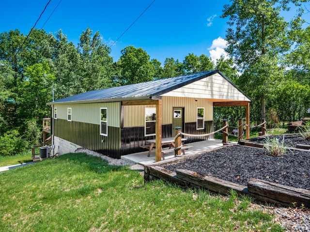 back of property featuring covered porch, a yard, and central AC