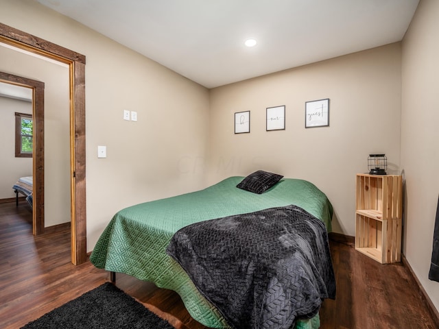 bedroom with dark hardwood / wood-style flooring