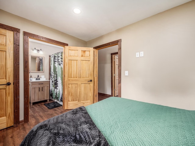 bedroom featuring ensuite bathroom, sink, and dark hardwood / wood-style floors