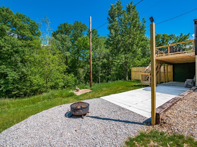 view of yard with a patio area, a wooden deck, and an outdoor fire pit