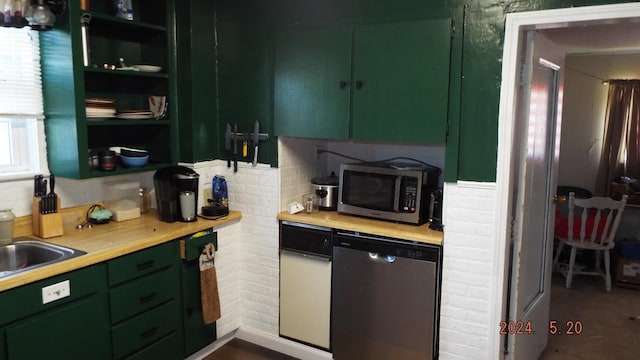 kitchen featuring green cabinets, appliances with stainless steel finishes, and wooden counters