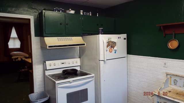 kitchen featuring brick wall, extractor fan, white appliances, and green cabinetry