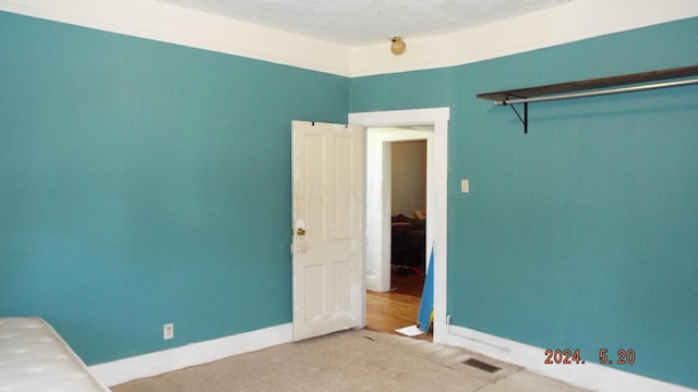 carpeted empty room featuring a textured ceiling