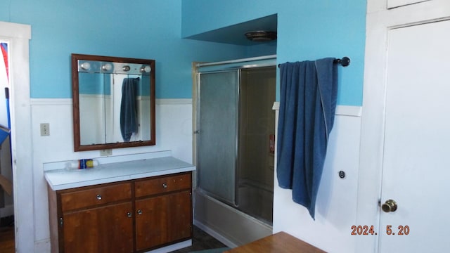 bathroom with vanity and bath / shower combo with glass door