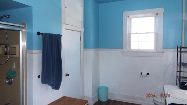 bathroom with a shower with door, vanity, hardwood / wood-style floors, and toilet