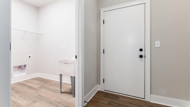 washroom with hookup for an electric dryer and light wood-type flooring