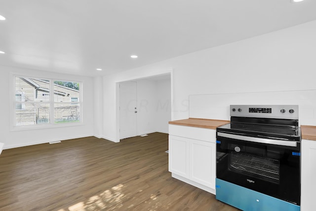 kitchen featuring butcher block countertops, white cabinetry, stainless steel range with electric cooktop, and dark wood-type flooring