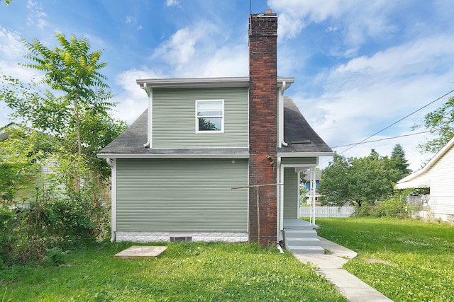 rear view of house featuring a lawn