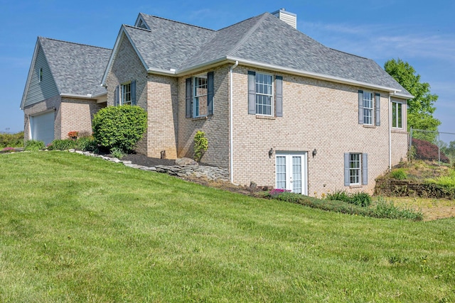 view of side of property featuring a yard and a garage