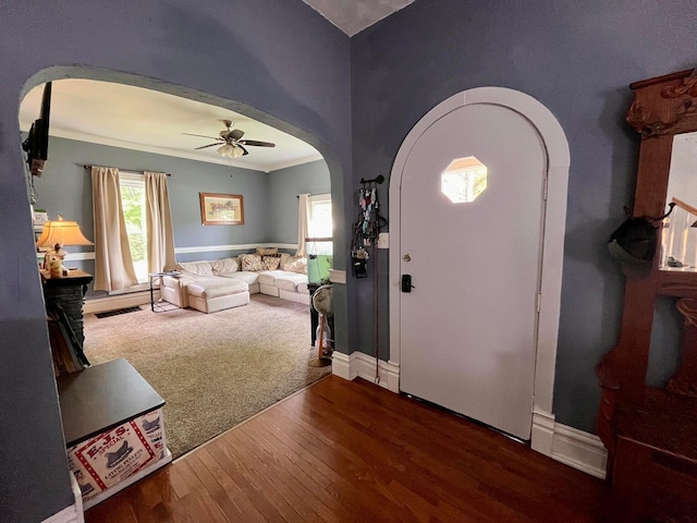 foyer entrance featuring wood-type flooring, ceiling fan, and ornamental molding